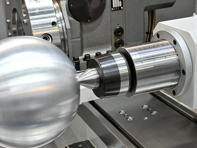 Eine fortschrittliche CNC-Maschine zeigt eine rotierende Metallkugel in der Bearbeitung.